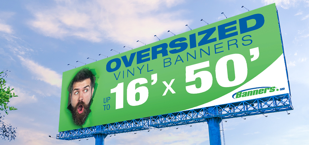 Large vinyl banner with green background and cutout of an excited brown haired bearded man. Blue text that reads Oversized Banners Up To, and white text that reads  16' x 50'